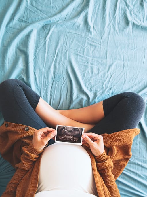 pregnant mother holds her ultrasound picture of her baby