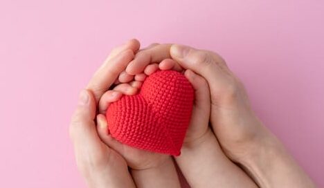 mother and child hands holding stuffed heart